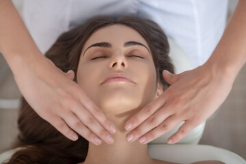 Fototapeta na wymiar Professional massage therapist putting hands on customers neck