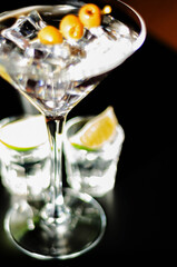 Traditional drink based on gin and vermouth with olives and ice cubes in a cocktail glass