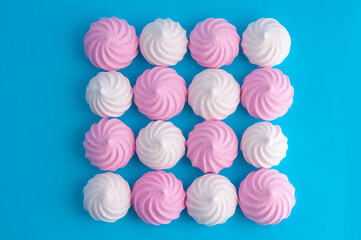 White and pink meringues on a blue background.