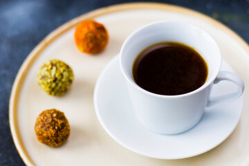 Obraz na płótnie Canvas Coffee espresso and truffles balls on the plate