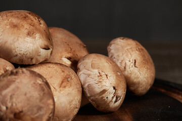 Fresh brown champignon mushrooms on wooden table.