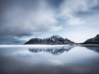 Skagsanden beach, Lofoten islands, Norway. Mountains, beach and clouds. Long exposure shot. Night time. Winter landscape near the ocean. Norway - travel