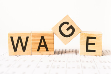 Word wage. Wooden small cubes with letters isolated on white background with copy space available.Business Concept image.