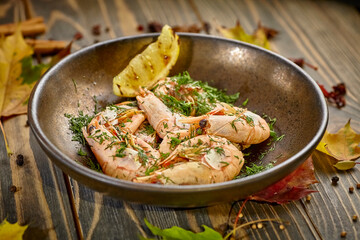 Boiled prawns with lemon and dill are on a plate