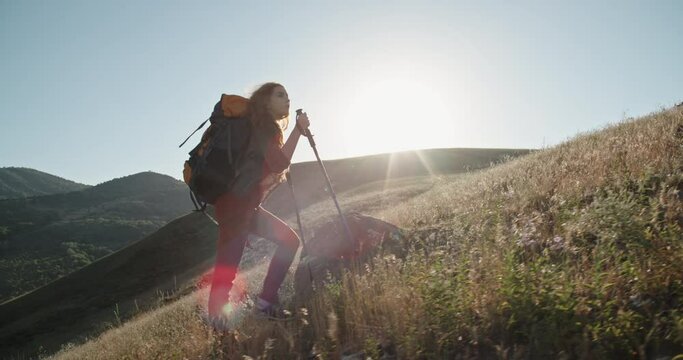 Young redhead girl hiking in mountains. Young beautiful woman backpacking in gorgeous landscapes, finding inspiration in adventure - freedom, nature, tourism 4k footage