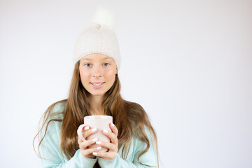 Smiling beautiful girl in winter clothes with a cup