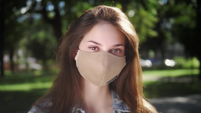 Young woman takes off protective face mask and breathes deeply and smiling looking at camera. Pandemic Covid-19. Happy end quarantine and home isolation. Victory over coronavirus.