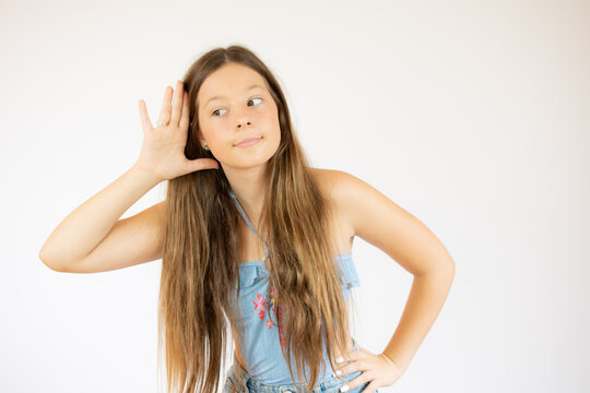 Beautiful girl with long hair making the listening gesture