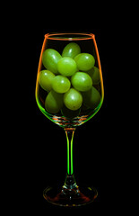 Green grapes in a colored wine glass