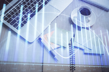 Obraz premium Stock market graph and top view computer on the table background. Double exposure. Concept of financial education.
