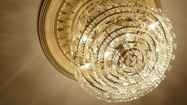 Canada - July 13, 2018: Elegant chandelier with hanging crystal balls and illuminated bulbs looking beautiful on pattern ceiling in a luxurious hall