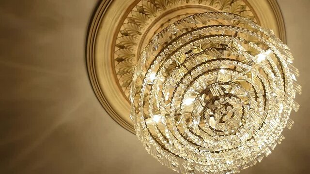 Canada - July 13, 2018: Illuminated chandelier with hanging crystal balls and glowing bulbs looking beautiful on ceiling in a luxurious hall