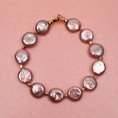 Purple baroque pearl bracelet on pink background