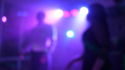 funny holiday in club, people silhouettes, dancing, music, light show. A group of young, stylish multi-ethnic people have fun and dance during a colorful party.