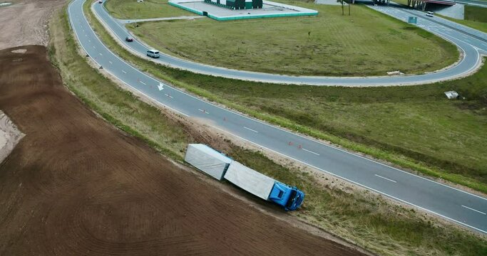 Truck crash drone shooting. Truck lies inverted in a ditch. Truck driver has an accident