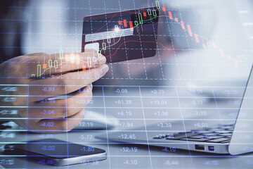 Multi exposure of woman on-line shopping holding a credit card and financial graph drawing. Stock market E-commerce concept.