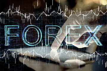 Double exposure of man's hands holding and using a digital device and forex graph drawing. Financial market concept.