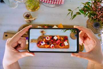 woman making photo of desserts on terrace