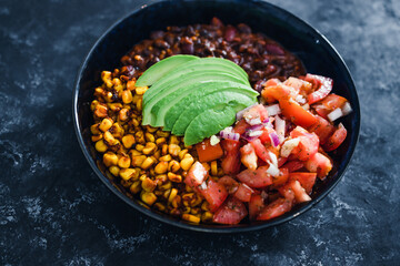 plant-based food,  vegan mexican style nourish bowl with spicy bean chilli avodaco corn and pico de gallo