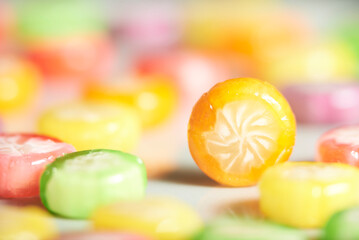 Candies of varied colors and flavors; an orange one stands out among them