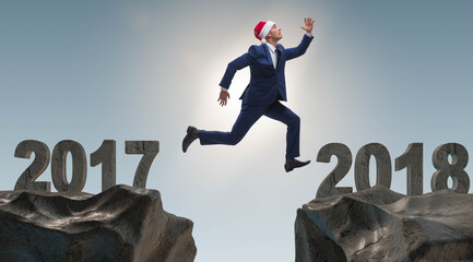 The businessman in santa hat jumping from 2017 to 2018