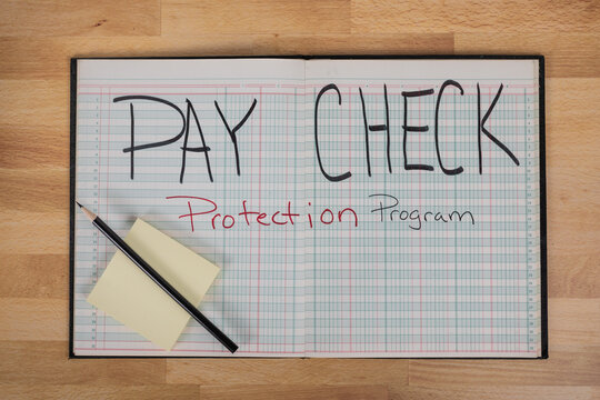 Paycheck Protection Program On A Business Ledger With Pencil And Posted Note 