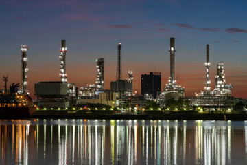 Oil refinery reflected along with river during twilight
