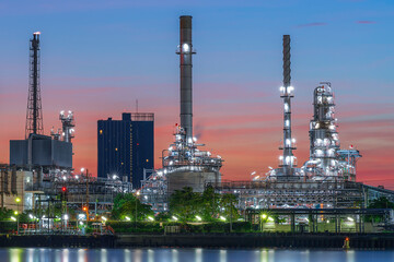 Oil refinery reflected along with river during twilight