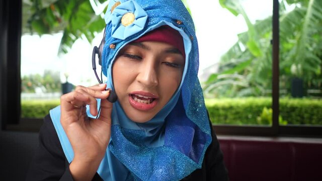 Young arab call operator businesswoman wears headset customer service manager looking and speaking to webcam.