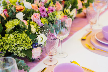 Close up of glasses for water and wine with table serving and flower center