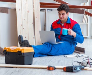 Young carpenter with a laptop computer