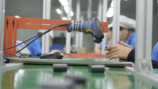 Female worker scanning adapters in factory on conveyor belt. Rack Focus. HD