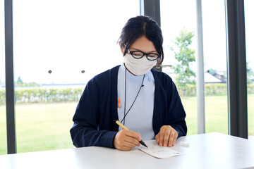 手紙を書く医療従事者の女性