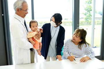 Obraz premium リハビリ中の患者と医療スタッフと赤ちゃん