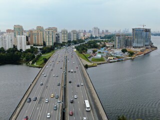 Aerial view car traffic on the bridge over the river expressway in the big city. Beautiful landscape of the city from the drone