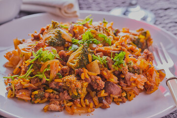 beef with rice and vegetables garnished with herbs.