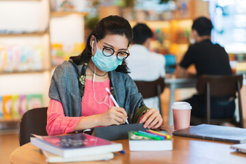 Asian woman wear protective face mask use tablet in public space