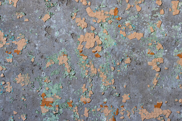 Peeling paint on the wall. Old concrete wall with cracked flaking paint. Weathered rough painted surface with patterns of cracks and peeling. High resolution texture for background and design. Closeup
