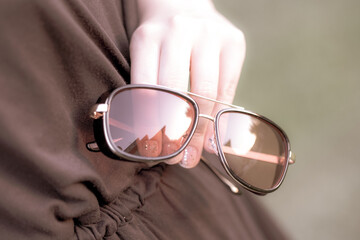 Retro sunglasses model with red lenses shoot in a sunny day in nature closeup. Selective focus