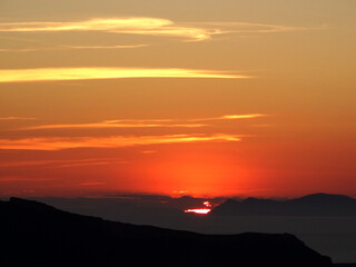Obraz premium Natural sunrise and sunset landscape above Nea Kameni island in Fira in Santorini Island, Greece. Fira is the modern capital of the Greek Aegean island of Santorini. 