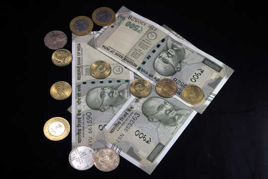 Indian currency. 500 rupee note with Indian coins. Indian currency isolated on black background.