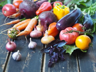 Agricultural background. Heap of fresh vegetables on a rustic wooden dark background. Close up.
