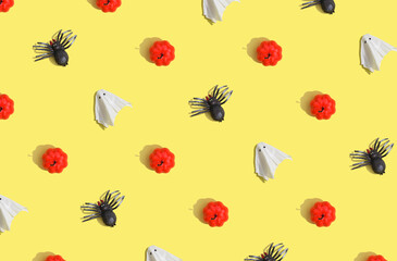 sunlight autumn pattern made with ghost, spider and pumpkin on bright yellow background.