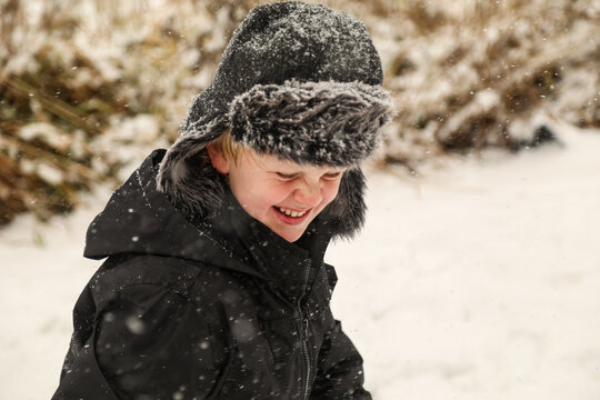 Young Boy Playing In The Snow With Scrunched Up Nose And Big Smile. Winter Happiness In Australia 2020