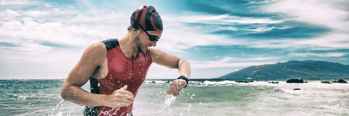 Triathlon competition swimmer man swimming looking at heart rate monitor tracker smartwatch....