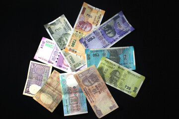 Now and old Indian currencies. 50, 100, 200, 500 rupee notes and coins. Indian currency isolated on black background.