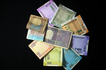 Now and old Indian currencies. 50, 100, 200, 500 rupee notes and coins. Indian currency isolated on black background.