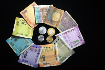 Now and old Indian currencies. 50, 100, 200, 500 rupee notes and coins. Indian currency isolated on black background.