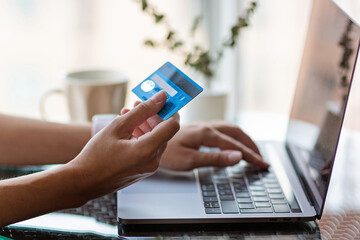 Young woman holding credit card and using laptop computer. Online shopping, e-commerce, internet...