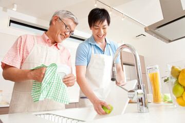 Obraz premium 食事の後片付けをする親子